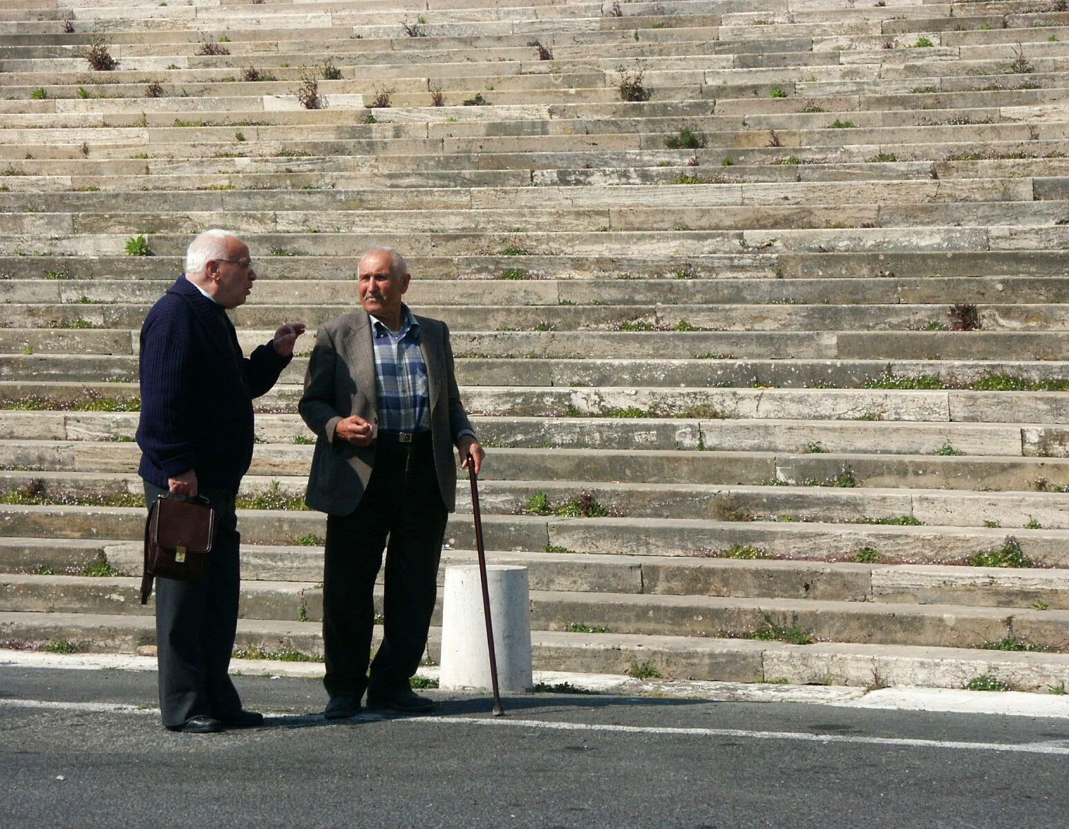 Anziani che conversano davanti a scalinata